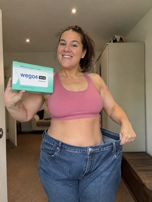 Real W6 customer holding her old giant jeans and W6 boxes